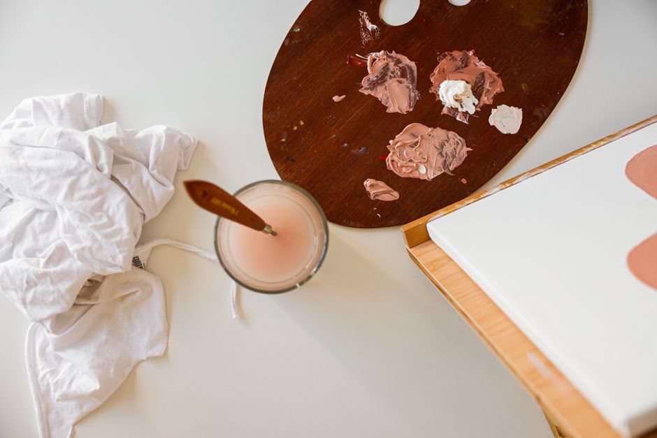 Top view of a painting setup with paint palette, brushes, and canvas, perfect for creative projects.